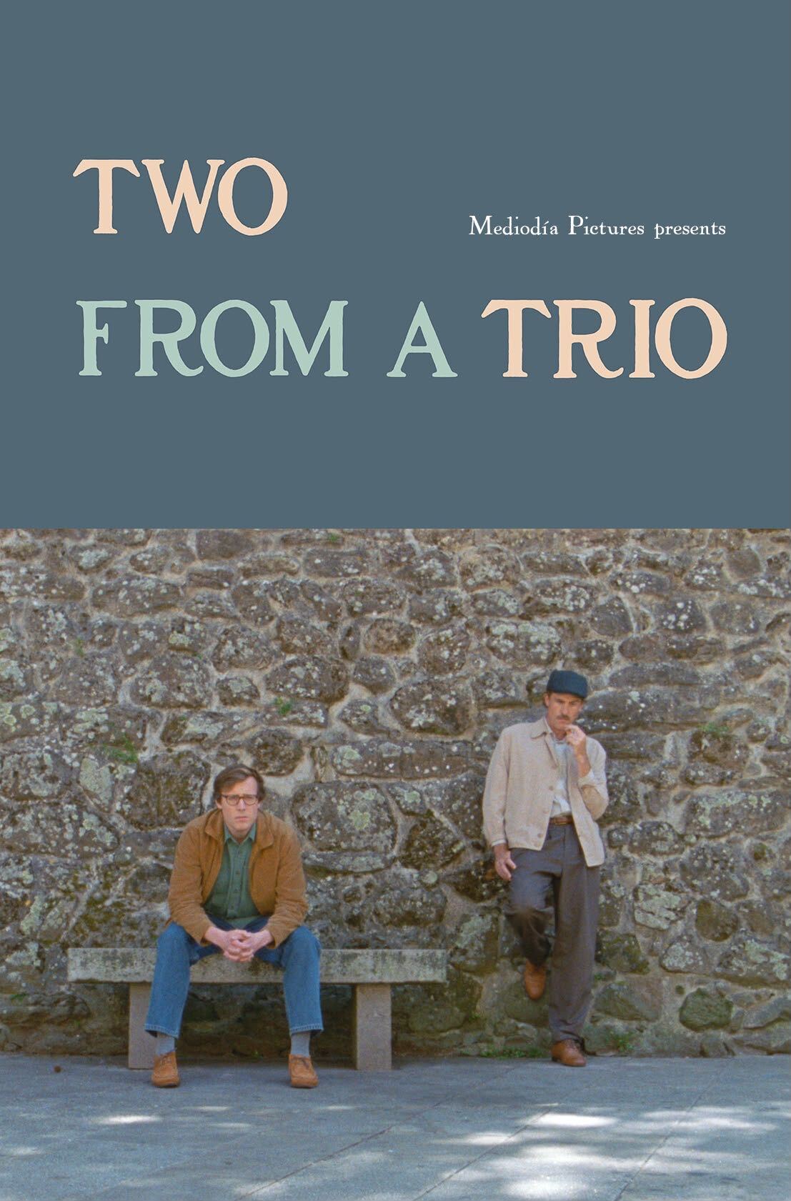 Two From a Trio poster — two men by a stone wall in Spain